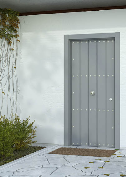 Puerta de entrada rústica con duelas verticales y clavos color gris