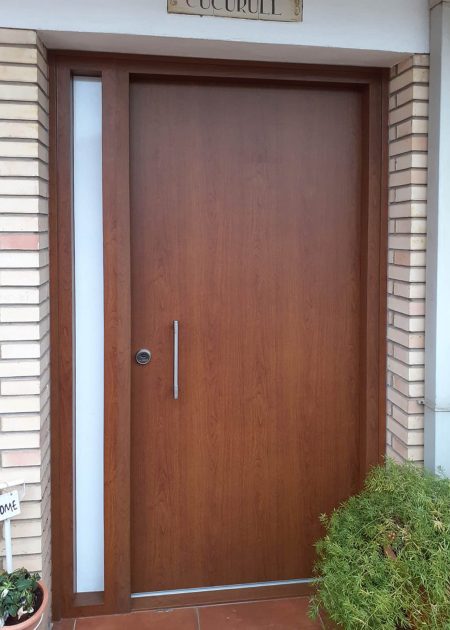 Puerta de entrada de aluminio lisa con fijo lateral con cristal imitación madera