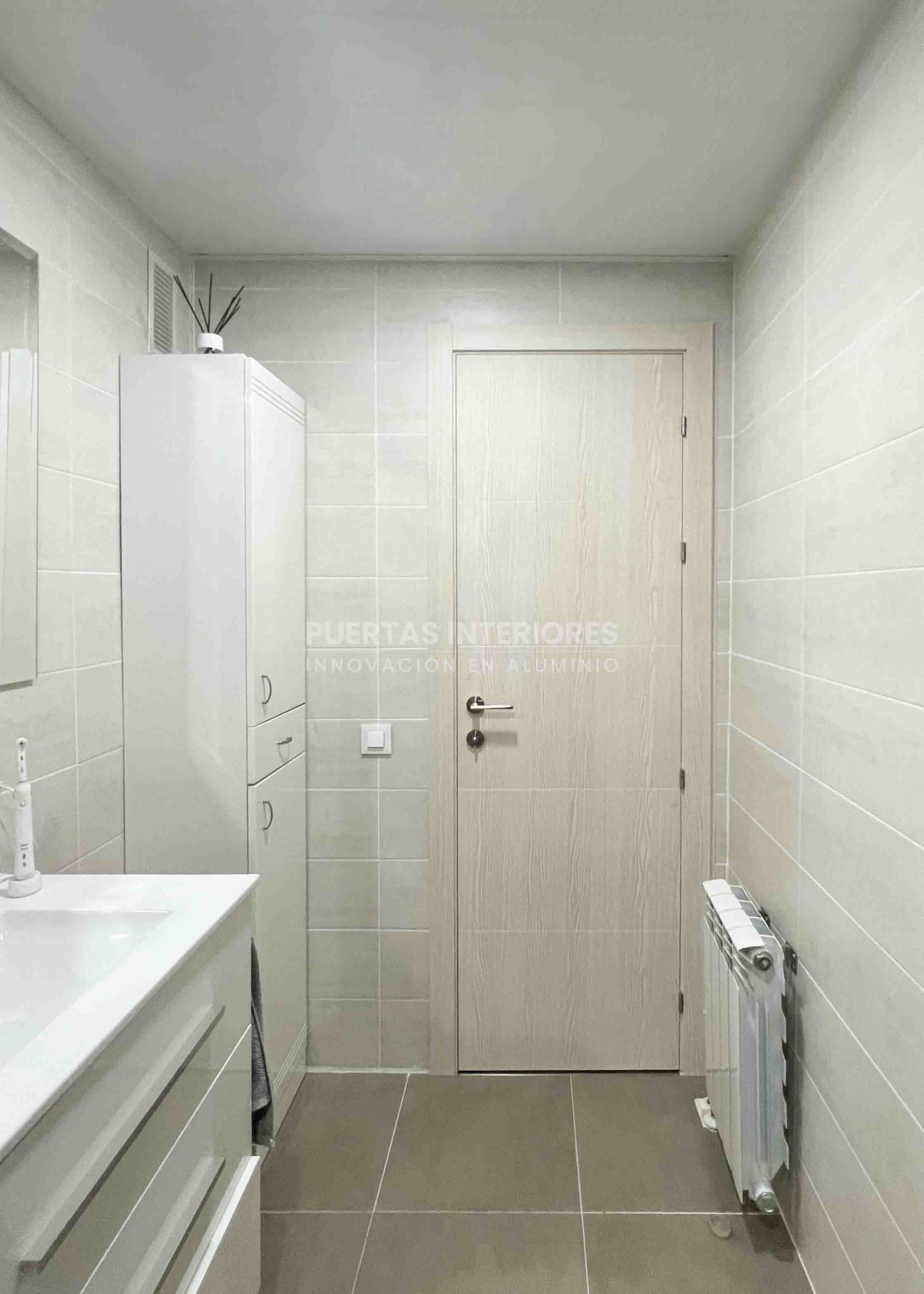 Puerta interior de aluminio antihumedad instalada en vivienda