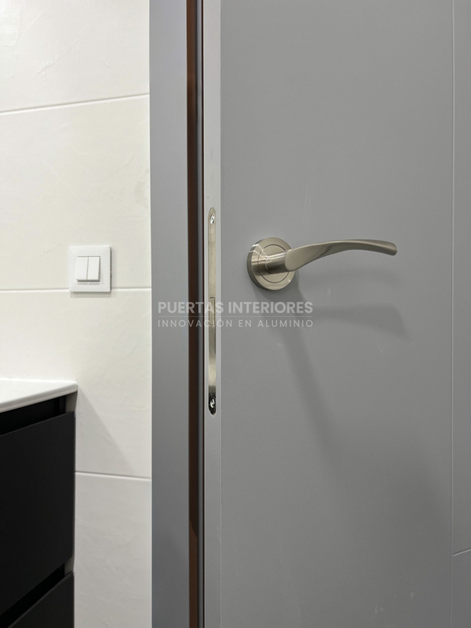 Puerta interior gris de aluminio instalada en baño