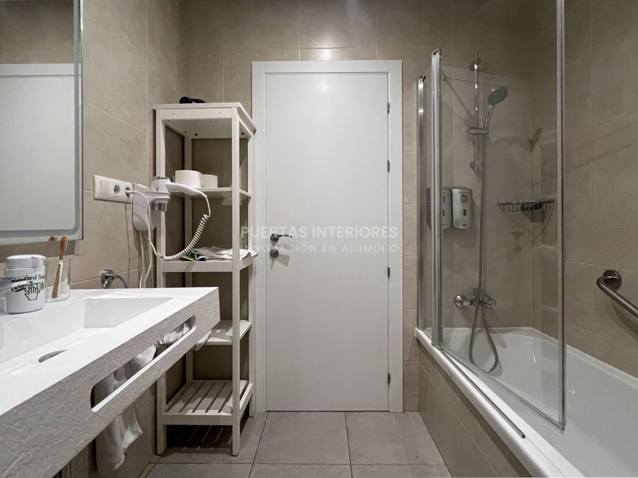 Puerta interior lisa blanca instalada en baño