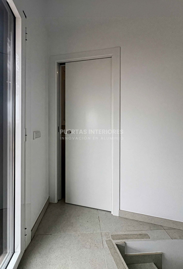 Puerta corredera interior blanca lisa instalada en baño