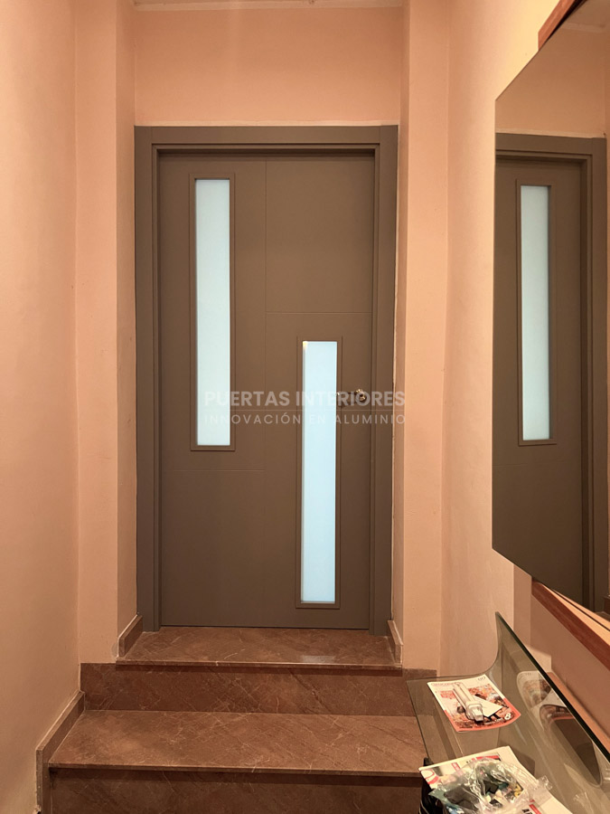 Puerta interior gris con rayas desiguales y vidrio